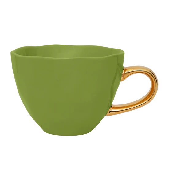 Grüne Tasse mit goldenem Henkel von Urban Nature Culture. 